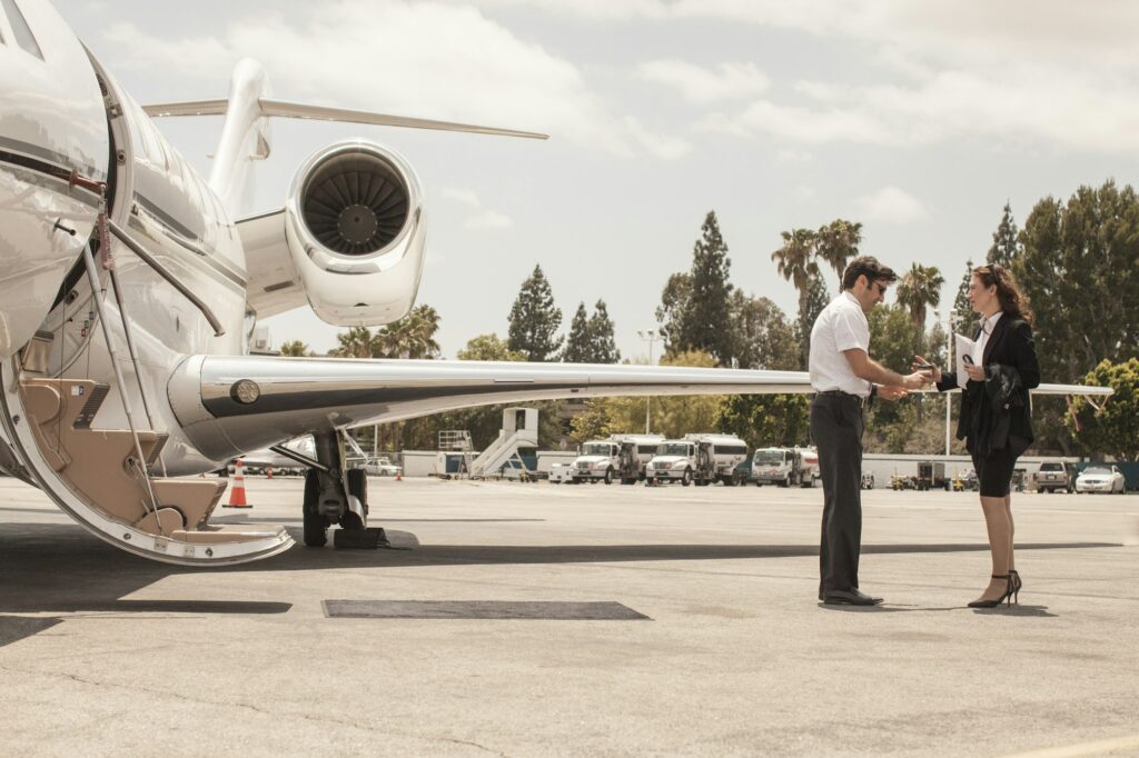 Female businesswoman shaking hands with private jet pilot at airport