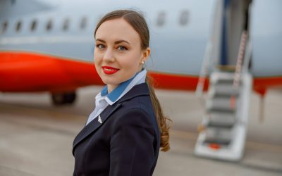 Joyful woman flight attendant standing outdoors at airport