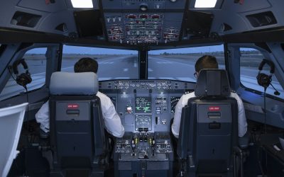 Two pilots in the cockpit of a commercial flight simulator preparing to start the flight